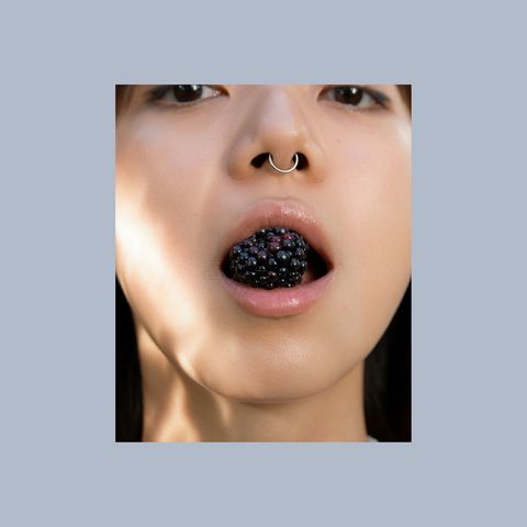 A Woman holding fruits in her mouth | CONTŌR | Medical spa in New York, NY