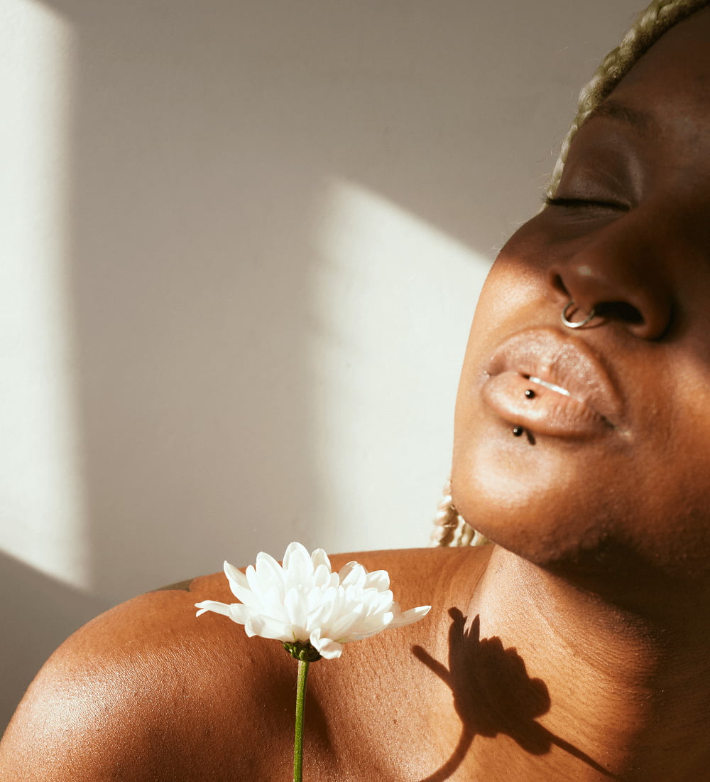 Portrait of a woman holding flower | Clinical Strength Peels Service in New York, NY | CONTŌR