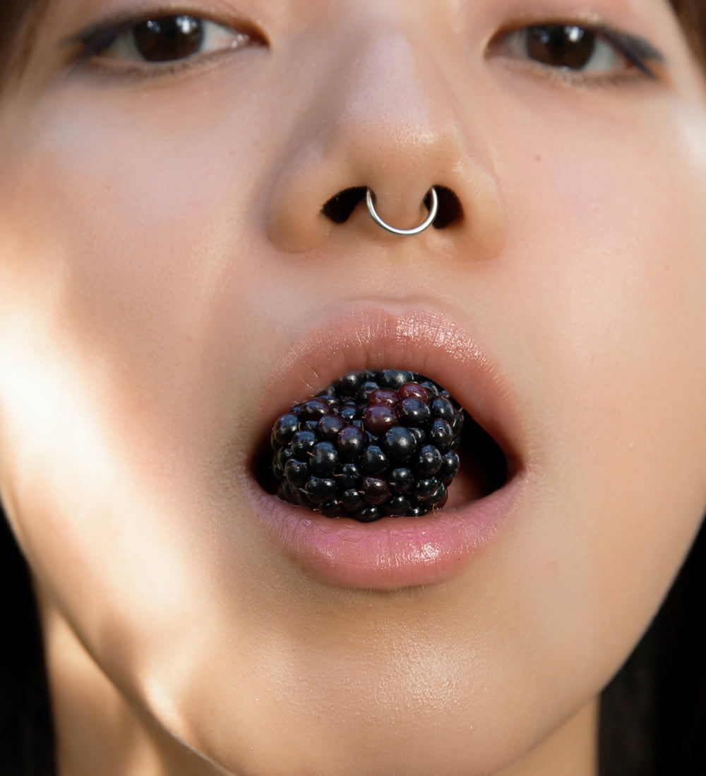 A Woman holding fruits in her mouth | Regenerative Microneedling service in New York, NY | CONTŌR